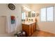 Bathroom showcasing a wooden vanity with sink, decorative mirrors and sconce lighting above, creating a cozy space at 39017 N Habitat Cir, Cave Creek, AZ 85331