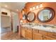 Bathroom features a granite countertop, double sinks, wood cabinets, tile flooring, and stone wall accents at 39017 N Habitat Cir, Cave Creek, AZ 85331