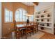 Sunlit dining room with shuttered windows, built-in shelves, and a wooden table with seating for six at 39017 N Habitat Cir, Cave Creek, AZ 85331
