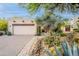 Charming Santa Fe-style home with desert landscaping, a two-car garage, and stone walkway to the front door at 39017 N Habitat Cir, Cave Creek, AZ 85331
