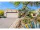 A two-car garage with desert landscaping and native cactus, complementing the Southwestern architectural style at 39017 N Habitat Cir, Cave Creek, AZ 85331