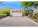Attached two-car garage featuring a desert landscape and neutral coloring complements the home's exterior at 39017 N Habitat Cir, Cave Creek, AZ 85331