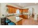 Well-lit kitchen with granite counter island, wood cabinets, stainless dishwasher, and breakfast bar at 39017 N Habitat Cir, Cave Creek, AZ 85331