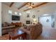 Bright living room featuring beamed ceilings, tile floors, fireplace and a large entertainment center at 39017 N Habitat Cir, Cave Creek, AZ 85331
