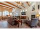Spacious living room boasts wooden beams, tile floors, and a fireplace creating a warm and inviting atmosphere at 39017 N Habitat Cir, Cave Creek, AZ 85331
