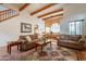 Comfortable living room showcases exposed beams, Saltillo tile, a dining area, and an open floor plan at 39017 N Habitat Cir, Cave Creek, AZ 85331