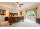 Serene primary bedroom suite featuring a rustic wood bed frame, neutral carpet, and a sliding glass door to a patio at 39017 N Habitat Cir, Cave Creek, AZ 85331