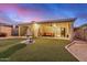 Picturesque backyard featuring a tiered fountain, manicured grass, and a covered patio with outdoor seating at 40713 N Citrus Canyon Trl, Phoenix, AZ 85086
