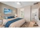 Comfortable bedroom with a plush bed, neutral decor, and access to an en-suite bathroom and laundry room at 40713 N Citrus Canyon Trl, Phoenix, AZ 85086
