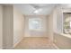 Bright bedroom featuring a white ceiling fan, tile floors, and a window with plantation shutters at 40713 N Citrus Canyon Trl, Phoenix, AZ 85086