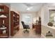 Cozy office with rich wood built-ins, a black leather executive chair, and natural light from the nearby doorway at 40713 N Citrus Canyon Trl, Phoenix, AZ 85086