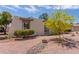 A front yard showcases desert landscaping featuring rocks and yellow flowering tree at 4803 W Harmont Dr, Glendale, AZ 85302