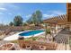 Beautiful in-ground pool features a covered patio, rock landscaping and wooden fence for outdoor enjoyment at 4803 W Harmont Dr, Glendale, AZ 85302