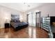 Elegant bedroom with a chandelier, hardwood floors, and large windows at 5136 W Trotter Trl, Phoenix, AZ 85083