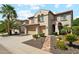 Beautiful exterior elevation featuring a stone pathway and lush landscaping with vibrant yellow flowers at 5136 W Trotter Trl, Phoenix, AZ 85083