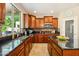 This kitchen offers cherry cabinets, stainless appliances, granite counters, a tiled backsplash, and a large window at 5136 W Trotter Trl, Phoenix, AZ 85083