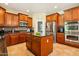 This kitchen features cherry cabinets, stainless appliances, granite counters, and a center island with seating at 5136 W Trotter Trl, Phoenix, AZ 85083
