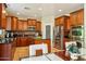 A gorgeous kitchen featuring cherry cabinets, stainless appliances, granite counters, and a pantry door at 5136 W Trotter Trl, Phoenix, AZ 85083