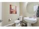 A clean powder room features a pedestal sink, toilet, and decorative accents at 5136 W Trotter Trl, Phoenix, AZ 85083