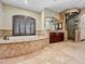 Luxurious primary bathroom featuring a soaking tub with shuttered window and glass enclosed shower at 5615 N Invergordon Rd, Paradise Valley, AZ 85253