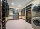 Spacious walk-in closet with custom built-ins, shelving, drawers, and in-unit laundry at 5615 N Invergordon Rd, Paradise Valley, AZ 85253