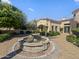 Beautiful home exterior featuring lush landscaping, stone fountain, and a brick-paved driveway at 5615 N Invergordon Rd, Paradise Valley, AZ 85253