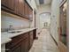 Hallway view with dark wood cabinets, sink and tan tile flooring throughout at 5615 N Invergordon Rd, Paradise Valley, AZ 85253
