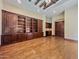 Open living room with wood floors, built-in shelves, and a wet bar at 5615 N Invergordon Rd, Paradise Valley, AZ 85253