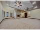 Cozy living room featuring a stone fireplace, ceiling fans, and plush carpeting at 5615 N Invergordon Rd, Paradise Valley, AZ 85253