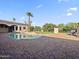 Beautiful backyard pool with brick patio, green grass and a palm tree in a desert landscape at 5615 N Invergordon Rd, Paradise Valley, AZ 85253