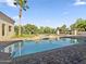 A luxurious pool area with a spa, lush landscaping and a tall palm tree under a beautiful clear sky at 5615 N Invergordon Rd, Paradise Valley, AZ 85253