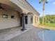 An outdoor view near the pool with a stucco wall and pillar accents overlooking a lush lawn with mature trees at 5615 N Invergordon Rd, Paradise Valley, AZ 85253