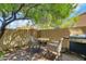 Private patio featuring woven chairs, a small table, a gas grill, and lush greenery for outdoor relaxation at 5704 E Aire Libre Ave # 1246, Scottsdale, AZ 85254