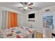 Bright bedroom boasts a ceiling fan, TV, and an open doorway to the kitchen at 6749 E Ellis St, Mesa, AZ 85205