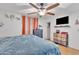 Bright bedroom featuring a ceiling fan, a TV, and built-in dresser at 6749 E Ellis St, Mesa, AZ 85205