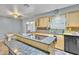 Open kitchen showcasing an island cooktop, light wood cabinets, and stainless dishwasher at 6749 E Ellis St, Mesa, AZ 85205