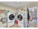 Laundry room with two white laundry machines and hot water heater at 6749 E Ellis St, Mesa, AZ 85205