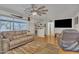 Living room featuring hardwood floors, a ceiling fan, TV and a sliding glass door at 6749 E Ellis St, Mesa, AZ 85205