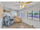 Sun room with two recliner chairs, windows, shelving and laminate floor at 6749 E Ellis St, Mesa, AZ 85205