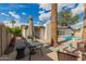 This backyard includes a patio, a pool, green shrubbery, and multiple palm trees at 6907 E Portland St, Scottsdale, AZ 85257