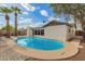 The backyard includes a bright blue pool, palm trees, and a home with white exteriors at 6907 E Portland St, Scottsdale, AZ 85257