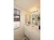 Bright bathroom features white cabinets, and a decorative mirror with lacey window covering at 6945 E Cochise E Rd # 117, Paradise Valley, AZ 85253