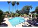 Community pool surrounded by palm trees and lounge chairs at 6945 E Cochise E Rd # 117, Paradise Valley, AZ 85253