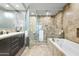 Elegant main bathroom with travertine walls, soaking tub, glass enclosed shower, and modern vanity at 7131 E Rancho Vista Dr # 7011, Scottsdale, AZ 85251