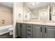 The primary bath has a double sink vanity with grey cabinets and dark wood floors, with a tub and shower at 7220 W Ashby Dr, Peoria, AZ 85383