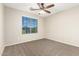 This bedroom features neutral walls, ceiling fan and carpet, and a large window with blinds at 7220 W Ashby Dr, Peoria, AZ 85383