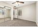 This bedroom features neutral walls, ceiling fan and carpet, closet with mirrored doors, and a window with blinds at 7220 W Ashby Dr, Peoria, AZ 85383
