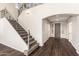 Grand foyer with a beautiful staircase, dark wood floors, and an arched doorway at 7220 W Ashby Dr, Peoria, AZ 85383