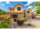 Charming two-story home showcasing desert landscaping, mature bushes, and a well-manicured yard at 7220 W Ashby Dr, Peoria, AZ 85383