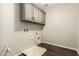The laundry room has overhead cabinets, with dark wood floors and neutral paint at 7220 W Ashby Dr, Peoria, AZ 85383